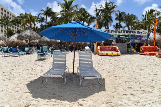 a group of lawn chairs sitting on top of a sandy beach